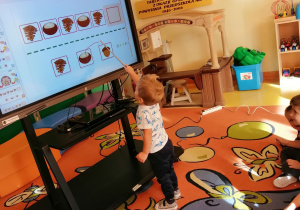Chłopiec wykonuje zadanie przy tablicy interaktywnej.