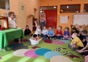 Przedszkolaki siedzą na dywanie, Pani Maria zadaje dzieciom pytania dotyczące bajki.