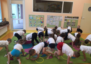 Dzieci wykonują ćwiczenie gimnastyczne.