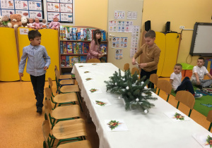 Dzieci szykują stół wigilijny.
