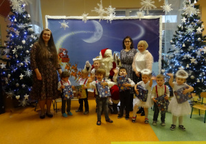 Dzieci pozują do zdjęcia z Panią Dyrektor, wychowawczyniami i Mikołajem.