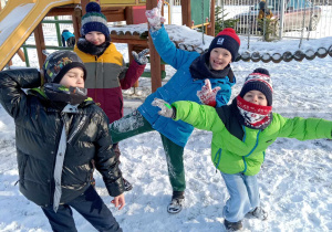 Na zdjęciu jest czterech chłopców znajdujących się w ogrodzie przedszkolnym.