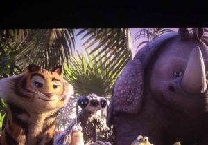 Na zdjęciu widać ekran kinowy, na którym są zwierzęta w dżungli.