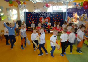 Dzieci tańczą w kole z chusteczkami.