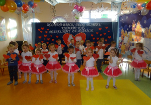 Dzieci śpiewają i tańczą z serduszkami.