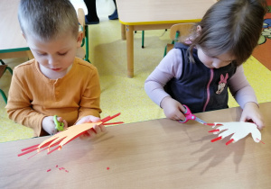 Dzieci obcinają paznokcie dłoni z papieru.