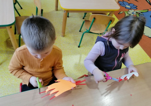 Dzieci obcinają paznokcie dłoni z papieru.
