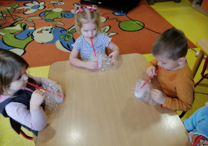 Dzieci wykonują bańki mydlane.