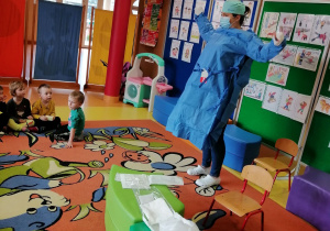 Pani Weronika prezentuje dzieciom swój strój pielęgniarki operacyjnej.