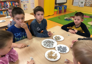 Dzieci wykonują ćwiczenia matematyczne z banknotami i monetami.