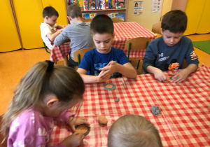Dzieci wykonują z masy solnej swoje monety.