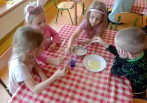 Dzieci wkrapiają barwniki do mleka.