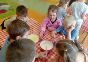 Dzieci wkrapiają barwniki do mleka.