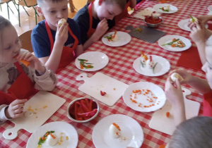 Dzieci zjadają przygotowane przez siebie kompozycje wielkanocne.