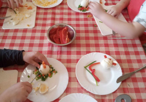 Dzieci wykonują kompozycje wielkanocne z jajek i warzyw.