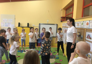 Dzieci wykonują ćwiczenia z fizjotrenerem.