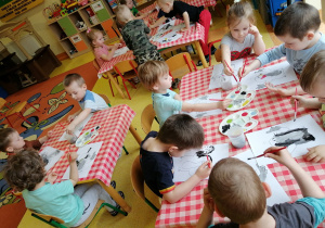 Dzieci malują farbami szablon kreta.