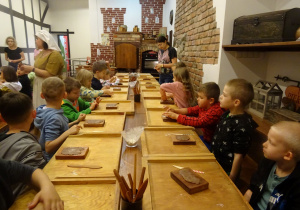 Przedszkolaki wkładają ciasto do foremek na pierniki.