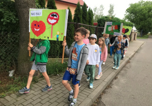 Dzieci maszerują ulicami osiedla z plakatami związanymi z Dniem Bez Tytoniu.