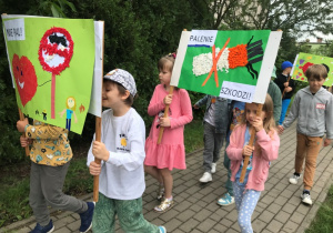 Dzieci maszerują ulicami osiedla z plakatami związanymi z Dniem Bez Tytoniu.